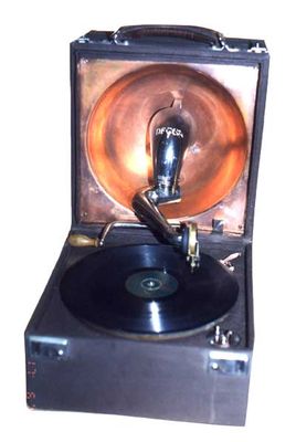 Decca (UK); (1930)
Tipo: Grammofono con movimento a molla e carica con  manovella
Mobile: in legno, rivestito di tela marrone scuro  
Dim. : 290x300xh 270 mm.  

